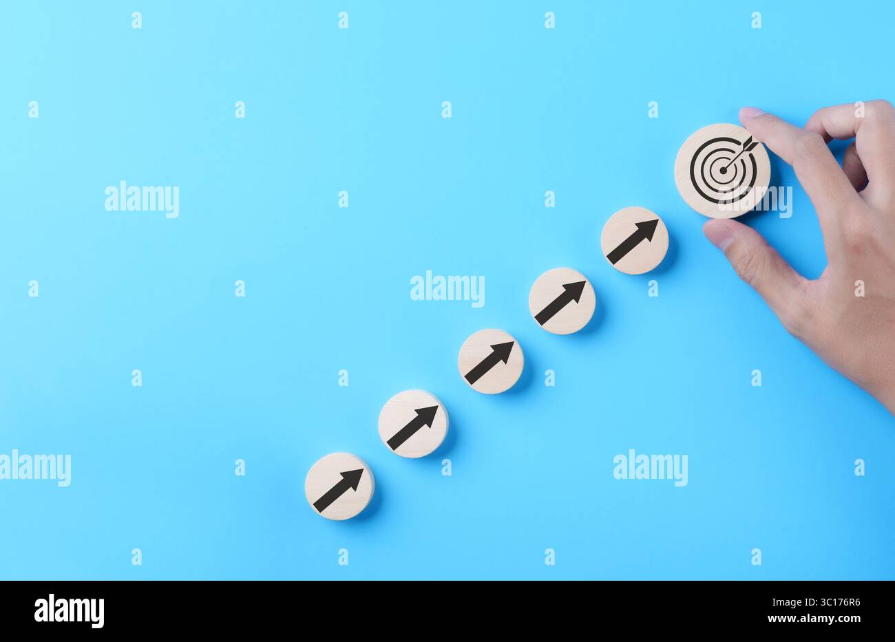 Objectif de réalisation de l'entreprise et concept de cible objective. Main d'homme d'affaires mettant la cible d'affaires virtuelle et la flèche qui écran sur le bloc de bois rond. Banque D'Images