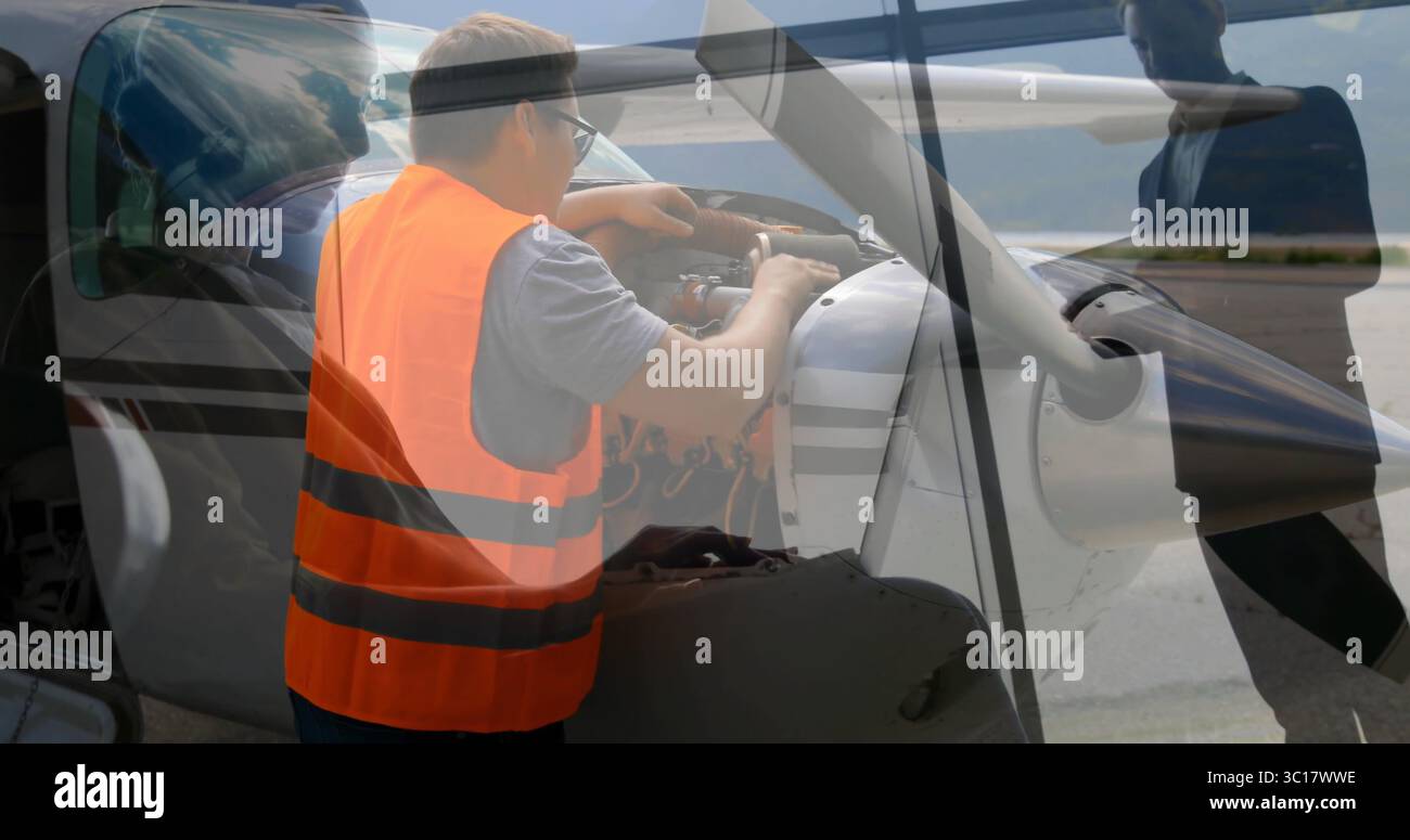 Homme en gilet haute visibilité vérifiant le moteur à travers le capot ouvert sur le tablier, avec équipage observant l'hélice Banque D'Images