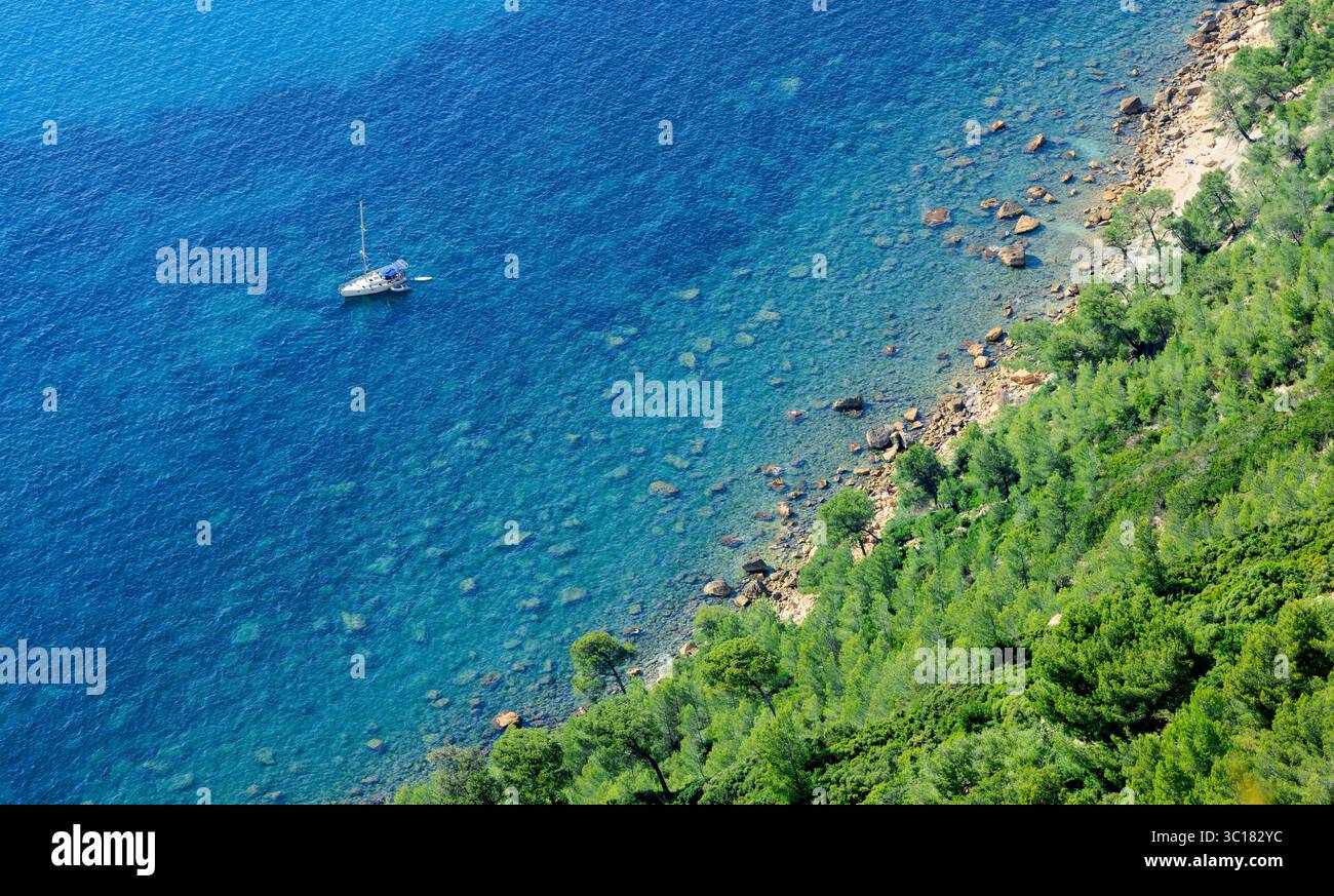Yacht solitaire dans la baie fantastiquement belle comme un symbole de vacances, de prospérité et de liberté financière à la mer Méditerranée - un vacances par Banque D'Images