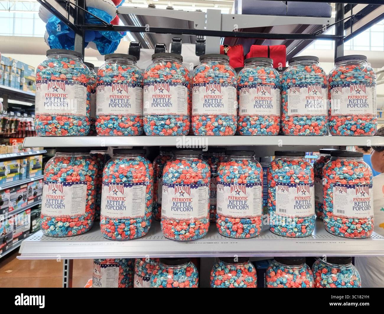 Étagères de magasin avec des conteneurs en plastique remplis de Wye River Patriotic Kettle Popcorn dans des couleurs rouge blanc bleu ; américain, États-Unis, États-Unis - Image de stock capturée avec un smartphone