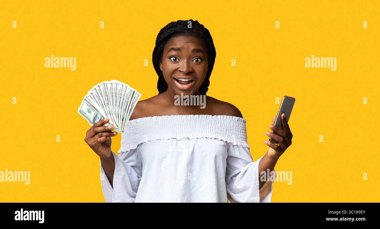 Concept de remboursement. Jeune femme enthousiaste tenant un smartphone et Dollar Cash Banque D'Images