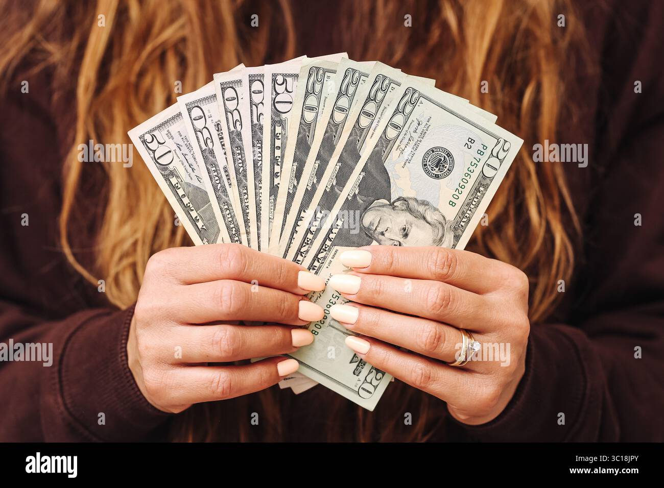 Femme tenant une pile de billets en dollars américains. Fan de vingt billets de dollars. Fermez les mains avec des ongles manucurés. Succès financier et économies. Banque D'Images