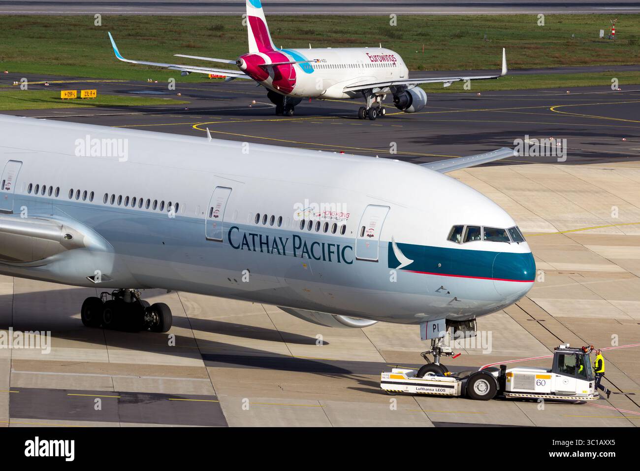 Cathay Pacific Boeing 777 (777-367ER) remorqué sur le tarmac après son arrivée à l'aéroport de Dusseldorf, présentant les opérations de manutention au sol et les aéronefs Banque D'Images