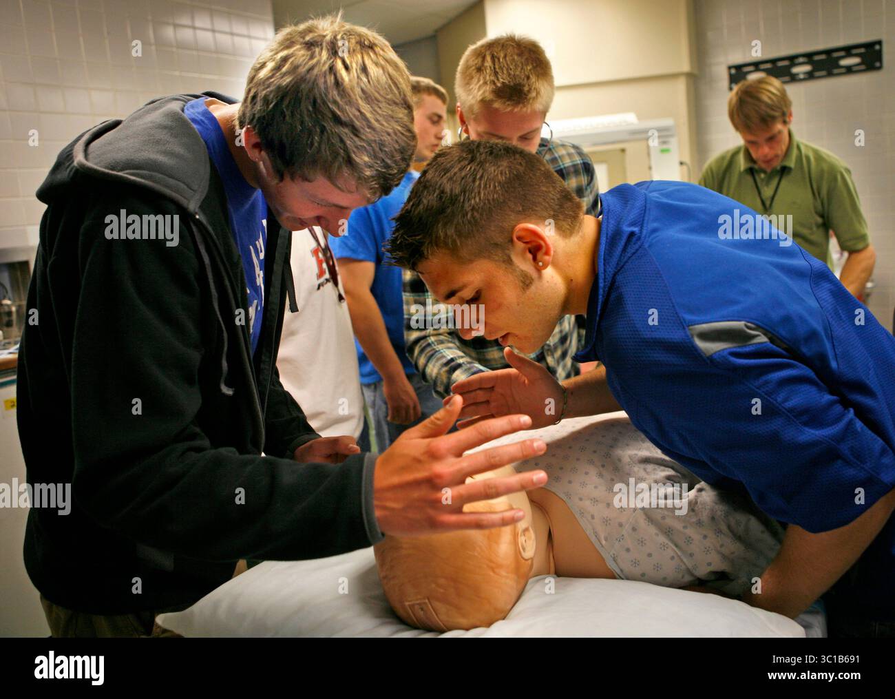 David Denney Minneapolis, MN 14 mai 2010 Steven Wehr, à gauche, et Halsey Aitchison, à droite, regardez dans le visage ombragé de ''SIM Man'' pour observer ses iris changer à la lumière tamisée. ''SIM Man'' aide les formateurs à créer des scénarios médicaux réalistes pour les étudiants. Ce jour-là, la faculté de médecine de l'U of M accueillait une visite de Kids dans la classe d'anatomie et de physiologie Anthony High de Chris Hergenrader. Ils ont établi un partenariat avec le Département d'Urologie de l'U de M. pour obtenir une école de médecine comme expérience quelques jours par an. Cela fait partie d'un effort pour susciter un intérêt pour la médecine parmi les enfants. (Crédit image : Minne Banque D'Images