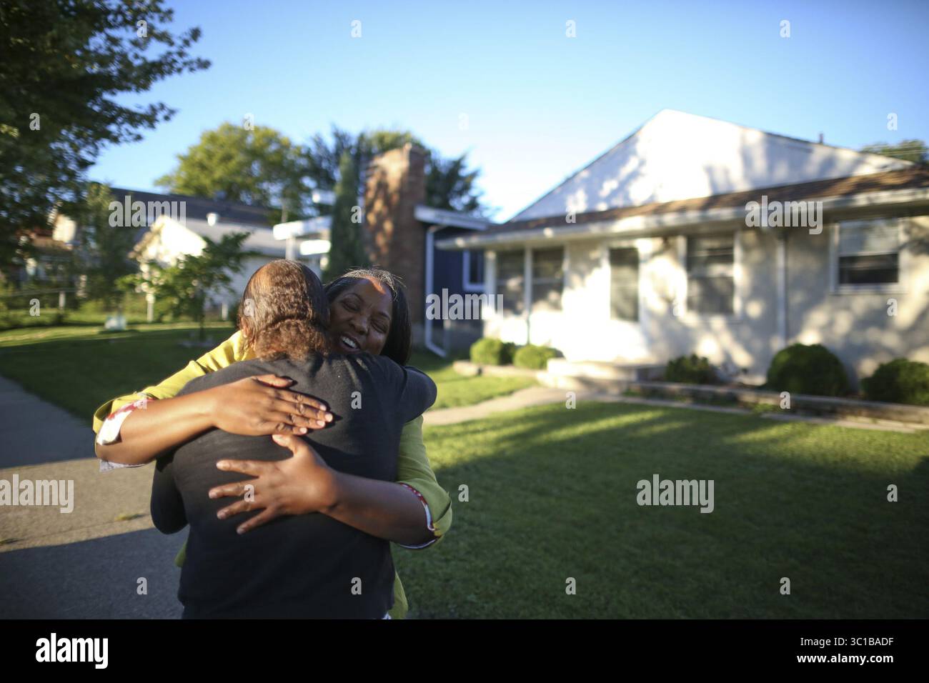 30 août 2016 - Minneapolis, MN, États-Unis - Kelly Martin, face à la caméra, qui a grandi dans la maison de Tilsenbilt derrière elle, a eu un câlin pour son ancienne voisine, Kim Collins, qui vient juste d'être dans le quartier. ....Tilsenbilt Homes dans le sud de Minneapolis, développé par Archie Givens, le premier millionnaire noir de Minneapolis, et le premier projet de logement intégré appuyé par le gouvernement fédéral au pays (milieu des années 50) est maintenant à l'étude pour devenir un district historique. Cornelious Martin, 84 ans, a élevé sa famille dans une maison de Tilsenbilt où il vit toujours sur la 5ème Avenue S. il a été photographié mardi soir, Augus Banque D'Images