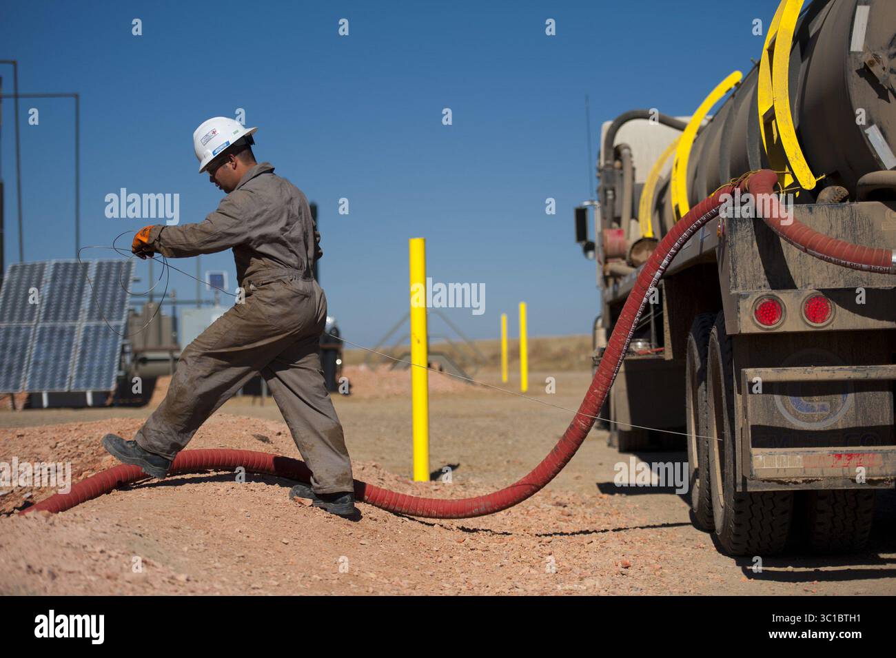 27 septembre 2011 - Williston, Minnesota, États-Unis - Kenny LeBaron de Minneapolis conduit un camion avec son frère cadet Joshua. Ils ont déménagé au Dakota du Nord pour profiter des salaires beaucoup plus élevés dus au boom pétrolier. Ici, Kenny a attaché un fil de mise à la terre avant d'enlever les déchets d'eau salée d'un nouveau puits de gaz et de pétrole Kodiak près de Watford City, Dakota du Nord. EDS : les noms sont cq des sujets. (Crédit image : Glen Stubbe/Minneapolis Star Tribune/TNS via ZUMA Wire) Banque D'Images