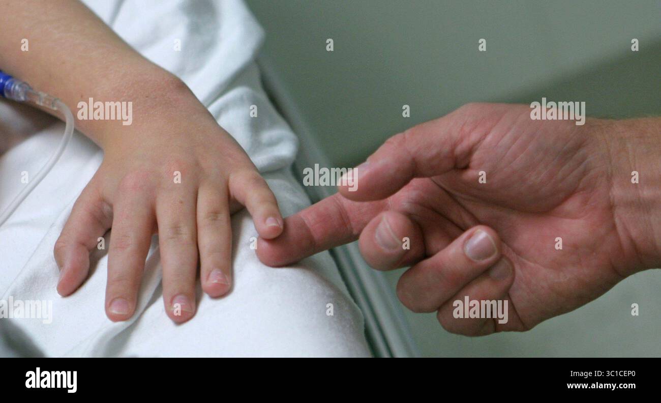 Oct 11, 2007 - Minneapolis, Minnesota, États-Unis - Paul Christophers, à droite, tient la main de sa fille Abi quelques minutes avant le début de sa chirurgie. ABI est né avec une malformation de Chiari. Cette malformation se produit pendant le développement fœtal et est caractérisée par un déplacement vers le bas de la partie inférieure du cerveau (amygdales cérébelleuses) sous le foramen magnum, dans le canal rachidien cervical. Ce déplacement bloque le flux normal du liquide céphalo-rachidien. Lorsque le flux normal est obstrué, un Seyx. ou une cavité peut se former dans la moelle épinière. Les symptômes ont tendance à se développer lentement, bien qu'une apparition soudaine puisse survenir Banque D'Images