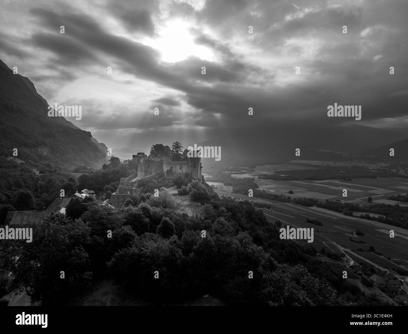 Vue aérienne du château de Miolans en France avec murs partiellement restaurés, palais, tours au ciel spectaculaire Banque D'Images