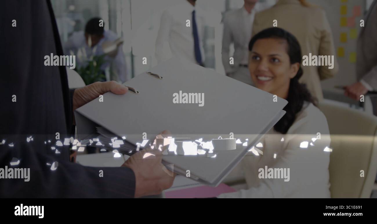 Réceptionniste assise d'Asie du Sud prenant une chemise grise à anneaux au bureau, avec un tableau de notes adhésives Banque D'Images