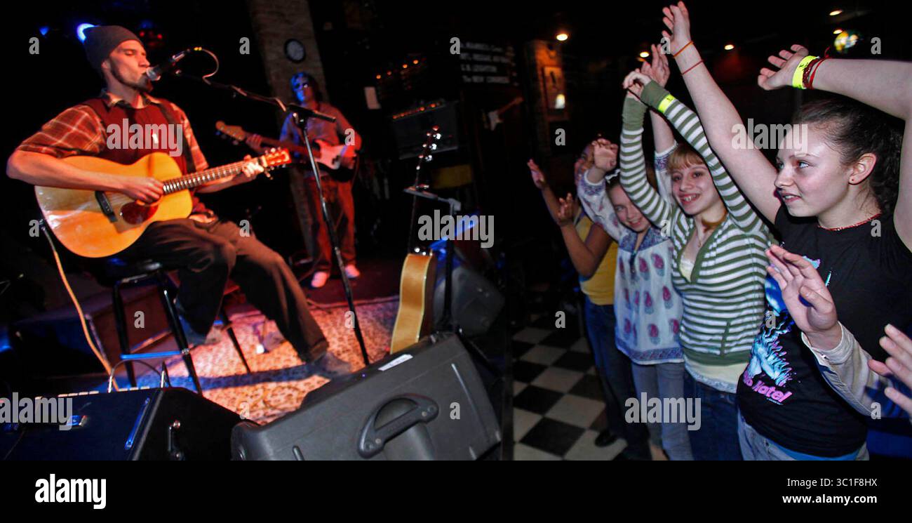 Attribuer. #00006743A février 8, 2009 - INFORMATIONS GÉNÉRALES : DANS CETTE PHOTO : neuf étudiants de Sanford Middle School à Minneapolis organisent une collecte de nourriture ce mois-ci. Le chanteur Ben Taylor a accepté de laisser les étudiants s'asseoir sur son temps de pratique de contrôle du son avant son concert prévu au Bunkers Bar and Grill. Les élèves se sont rassemblés autour de la scène pour écouter Taylor et ses musiciens s’échauffer. (Crédit image : Marlin Levison/Minneapolis Star Tribune/TNS via ZUMA Wire) Banque D'Images