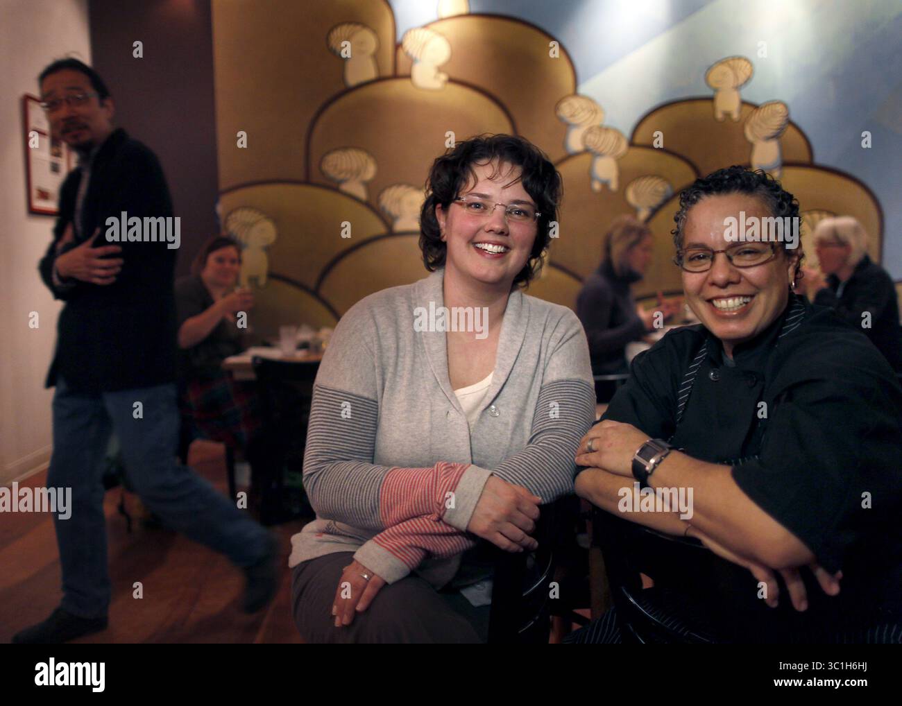 19 décembre 2011 - Minneapolis, Minnesota, États-Unis - gauche, Baker Solveig Tofte, et la chef Annette Colon à la boulangerie Sun Street Bread Restaurant. En arrière à gauche, Martin Ouimet, se faufilant hors de l'arrière-plan. Affectations #20021089A  15 décembre 2011  LIMACE : rn1222  INFORMATIONS SUPPLÉMENTAIRES : L'avis du restaurant est sur la nourriture du dîner : pourriez-vous tirer des tacos au pain frit, de la pâte de bœuf, du ragoût de crustacés, du ragoût trinity, du sandwich delta. Pour le bilan de l'année, pourriez-vous s'il vous plaît tirer les biscuits avec de la sauce à la saucisse ? Portraits : Baker Solveig Tofte, chef Annette Colon et co-propriétaire Martin Ouimet. Des tirs séparés seraient excellents, puis le ph Banque D'Images