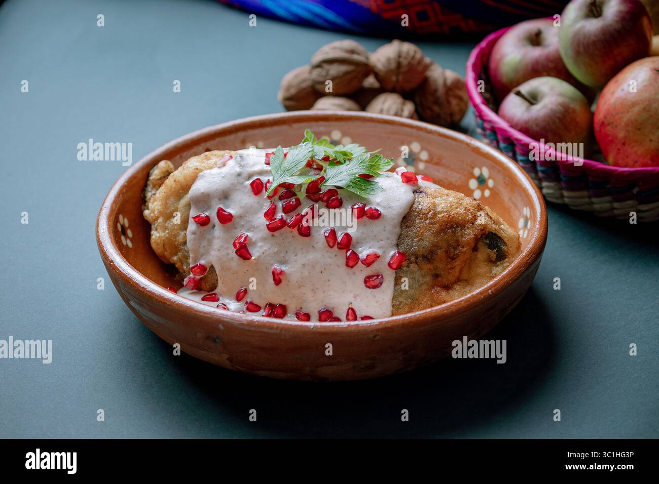 chile en nogada tranché pour révéler sa farce traditionnelle de viande et de fruits, recouverte de sauce crémeuse aux noix et de grenade. Banque D'Images