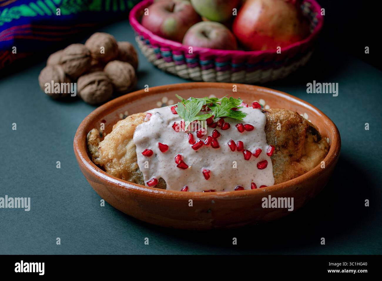chile en nogada tranché pour révéler sa farce traditionnelle de viande et de fruits, recouverte de sauce crémeuse aux noix et de grenade. Banque D'Images