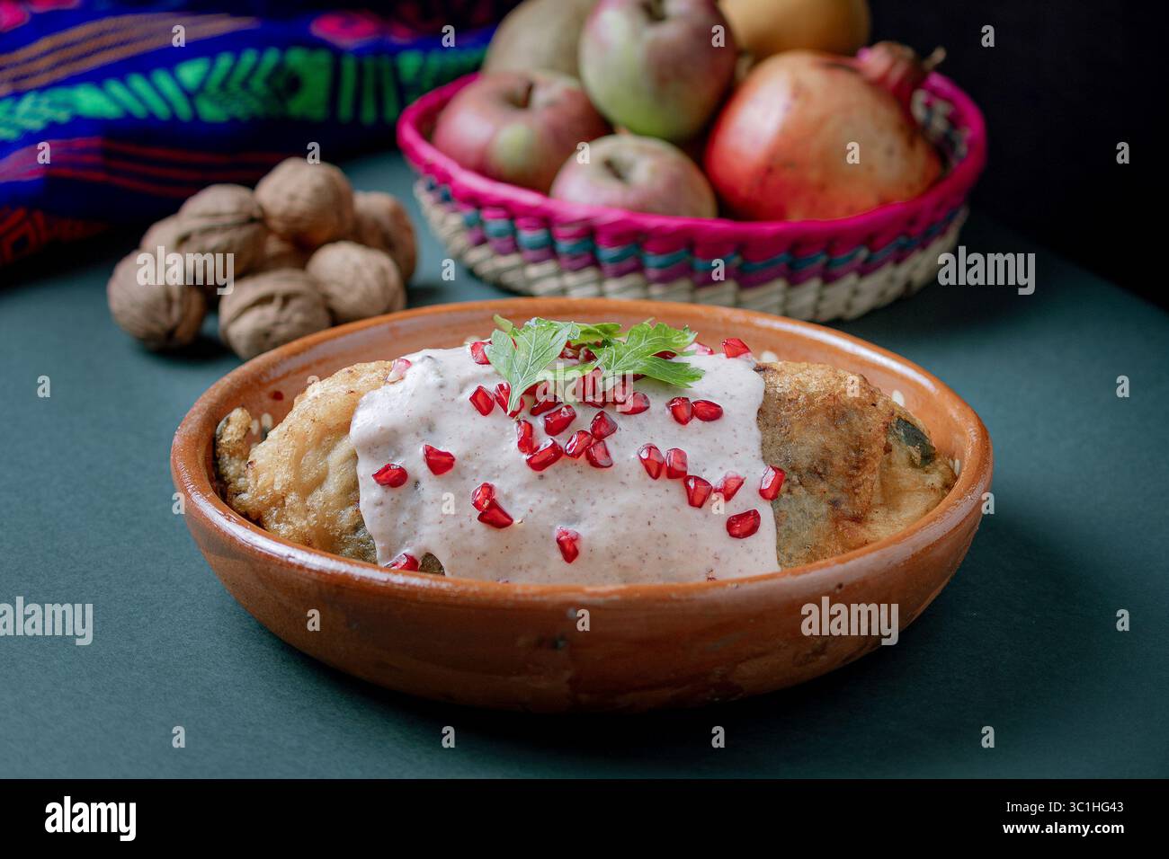chile en nogada tranché pour révéler sa farce traditionnelle de viande et de fruits, recouverte de sauce crémeuse aux noix et de grenade. Banque D'Images
