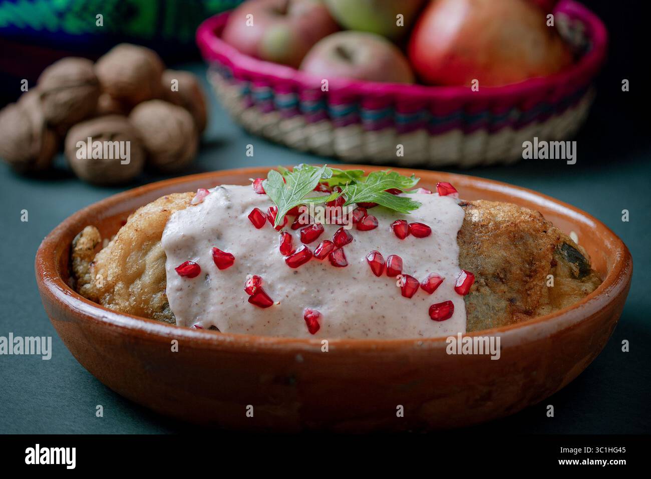chile en nogada tranché pour révéler sa farce traditionnelle de viande et de fruits, recouverte de sauce crémeuse aux noix et de grenade. Banque D'Images