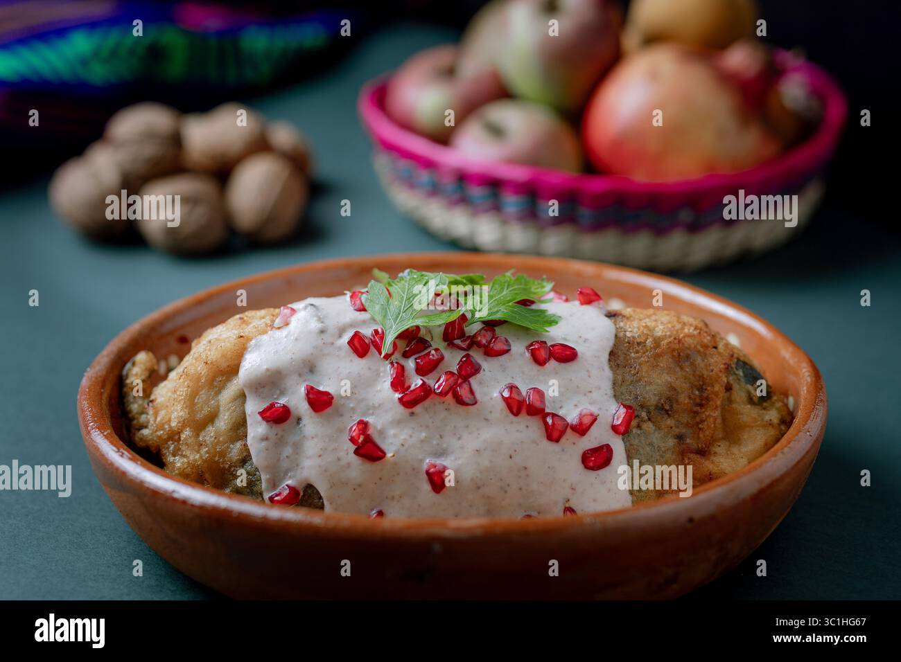 chile en nogada tranché pour révéler sa farce traditionnelle de viande et de fruits, recouverte de sauce crémeuse aux noix et de grenade. Banque D'Images