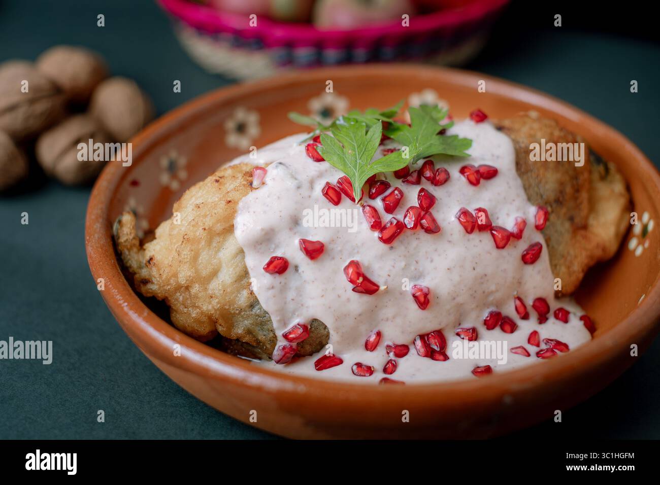 chile en nogada tranché pour révéler sa farce traditionnelle de viande et de fruits, recouverte de sauce crémeuse aux noix et de grenade. Banque D'Images