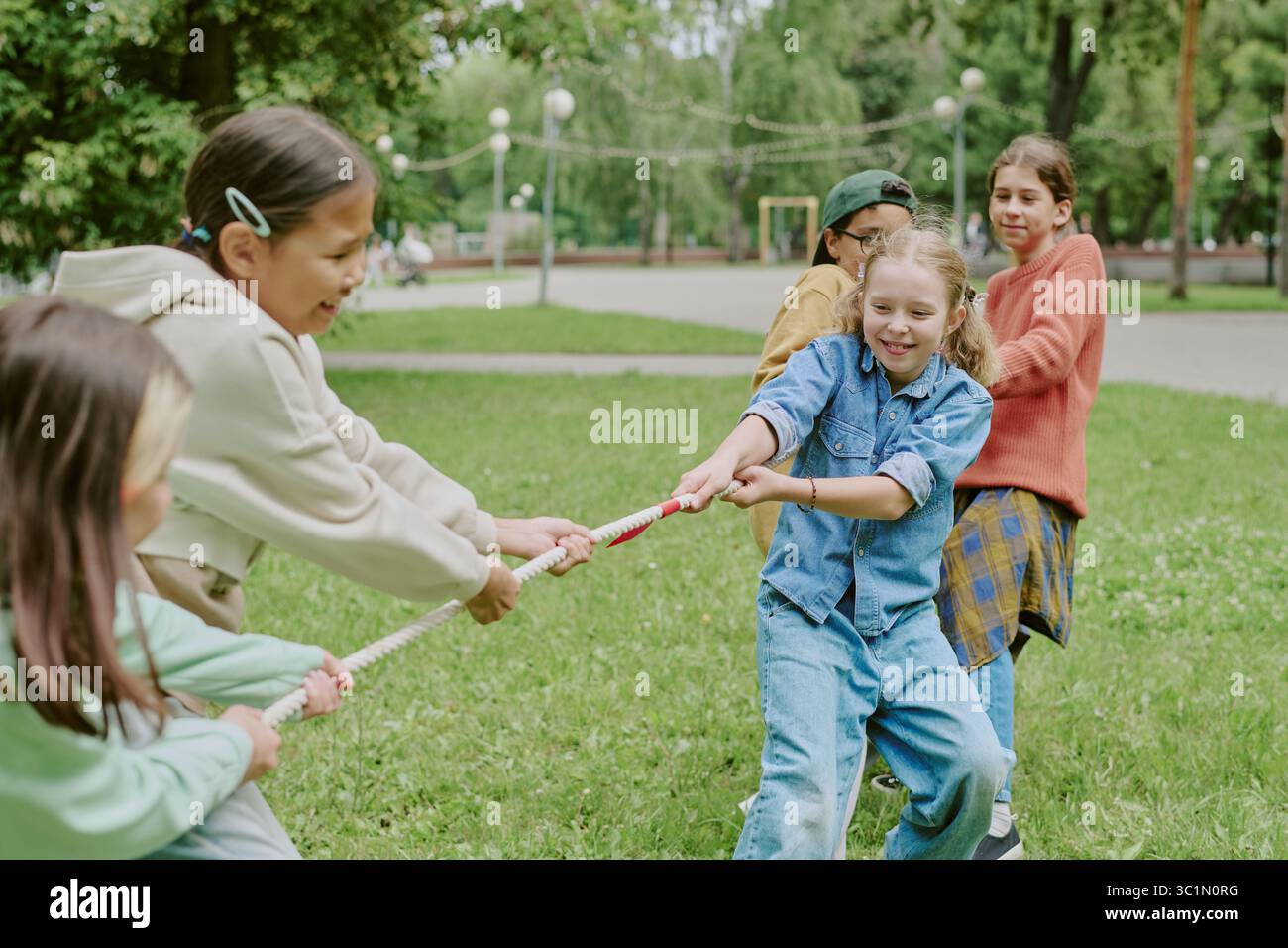 Enfants multiethniques jouant Tug of War dans le parc Banque D'Images