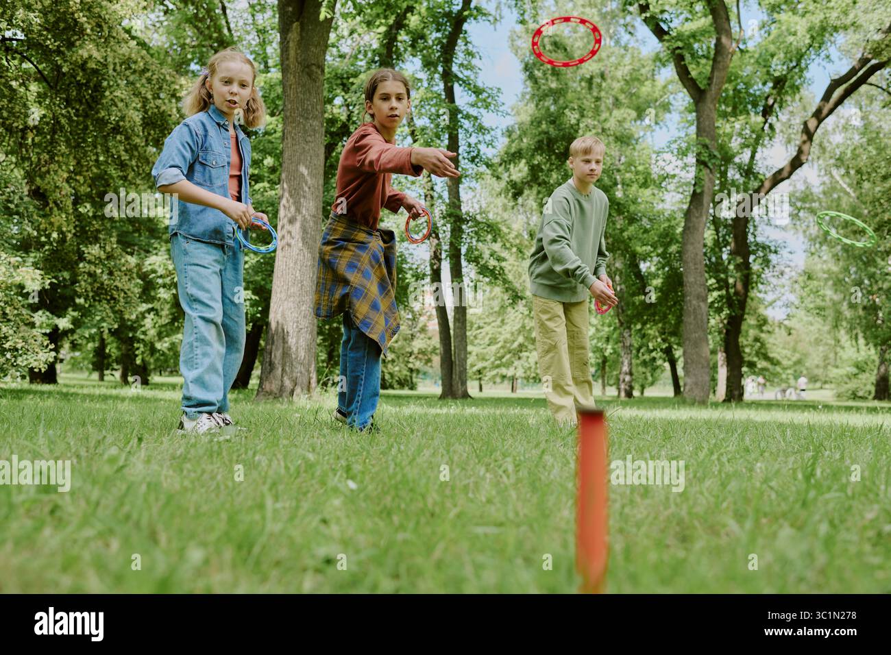 Groupe d'enfants caucasiens jouant Ring Toss Game à l'extérieur Banque D'Images
