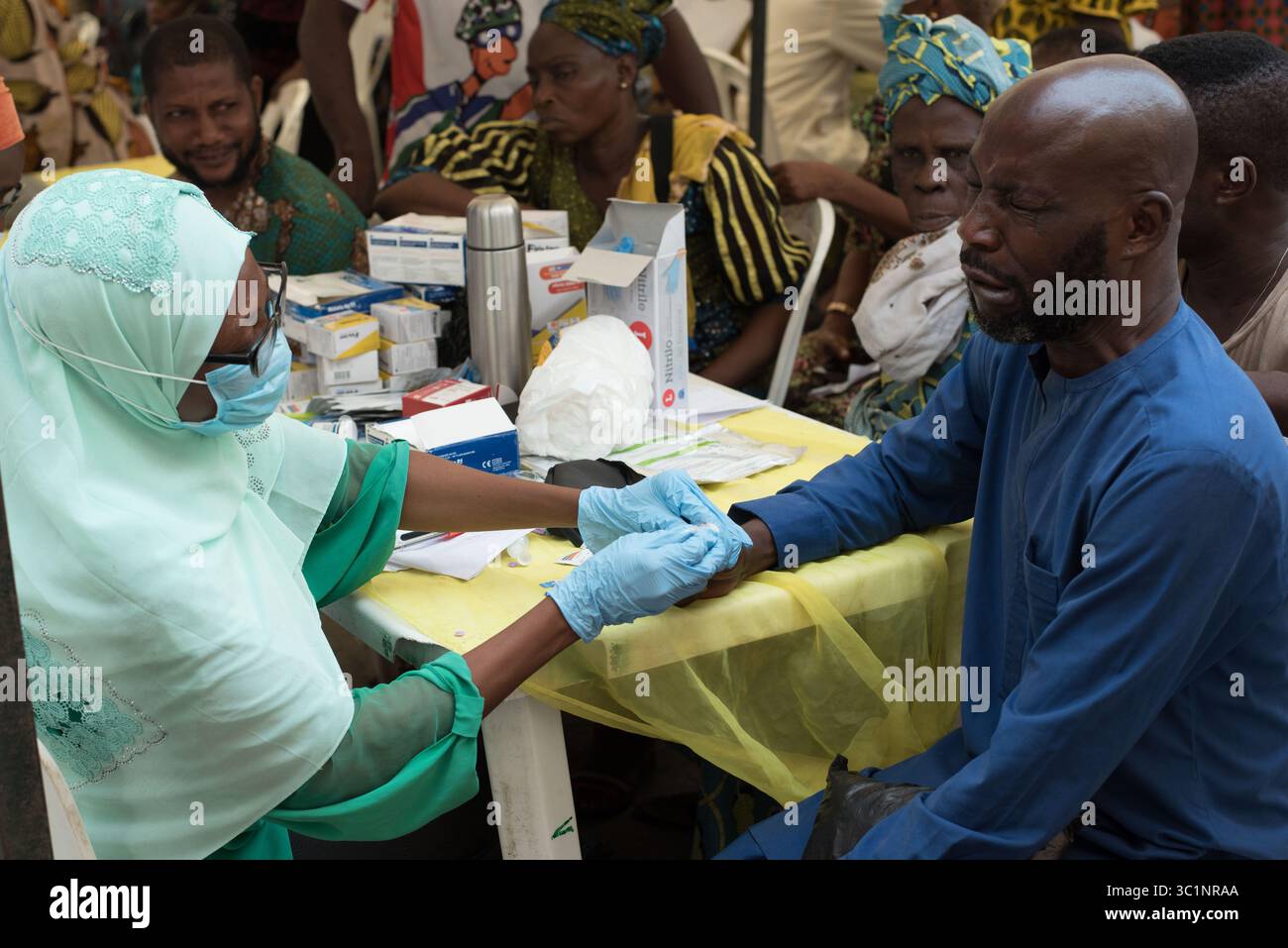Un homme écume alors que son échantillon de sang est prélevé au cours d'une campagne médicale organisée par le Président du gouvernement local de l'île de Lagos Banque D'Images