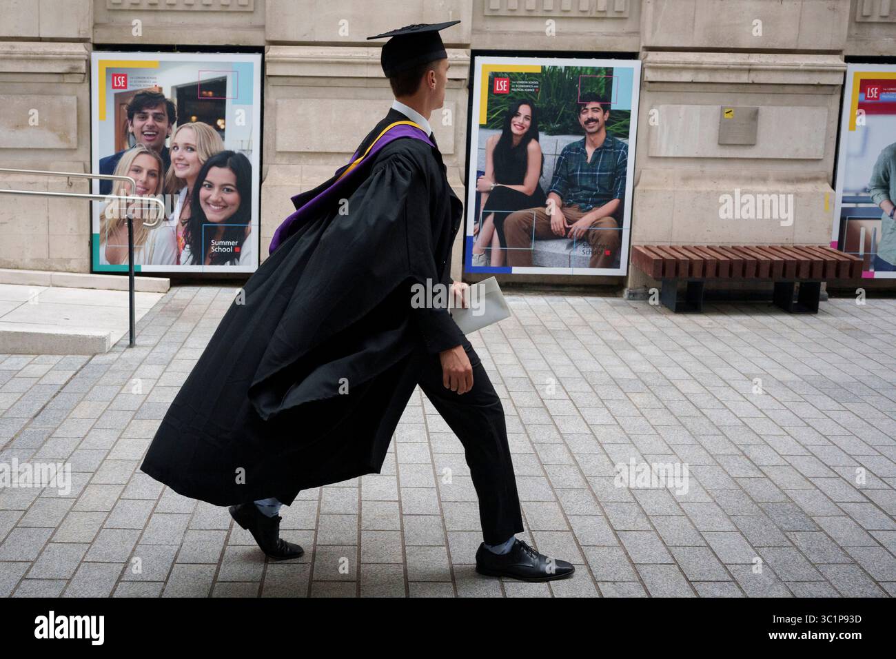 Un diplômé célébrant son diplôme de la London School of Economics (LSE) traverse le campus universitaire, le 22 juillet 2025, à Londres, en Angleterre. Banque D'Images