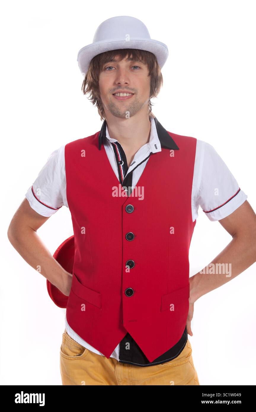 L'homme met en valeur son style unique dans un gilet rouge vif et un chapeau blanc à l'intérieur. Banque D'Images
