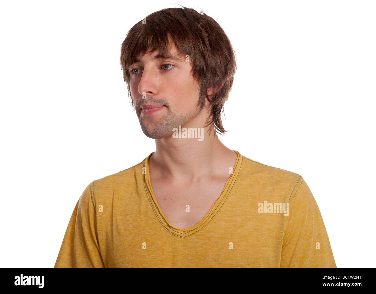 Un homme aux cheveux de longueur moyenne porte une chemise jaune éclatante qui semble réfléchie. Banque D'Images