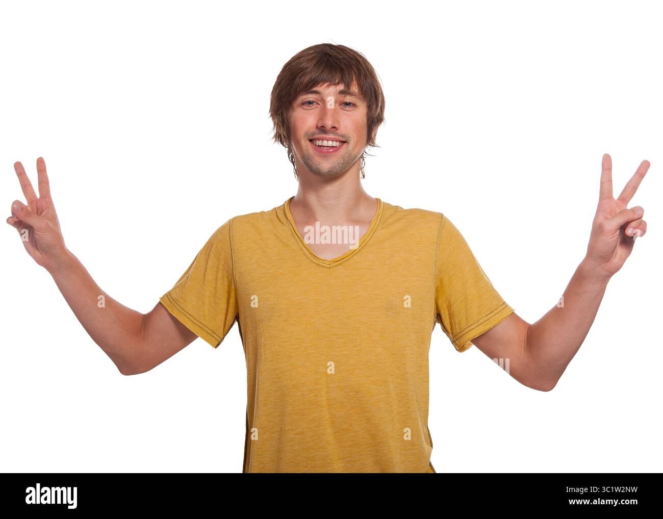Un jeune homme joyeux portant une chemise jaune montre des signes de paix avec les deux mains. Banque D'Images