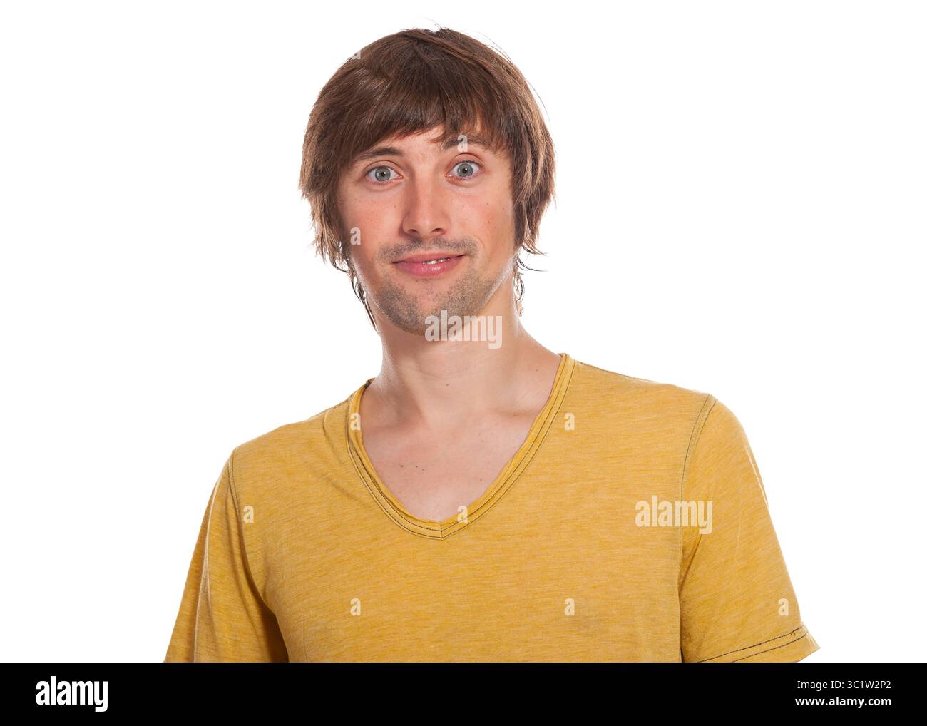 Un jeune homme joyeux aux cheveux courts pose de manière ludique, exsudant le bonheur et la convivialité. Banque D'Images