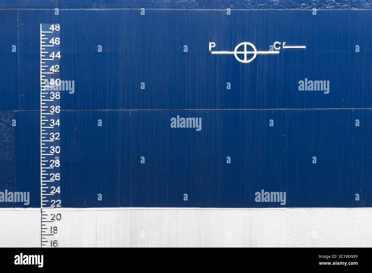 Image détaillée montrant les marquages de tirant d'eau et la ligne Plimsoll d'une coque de navire, sur fond bleu et blanc, symbolisant le génie maritime Banque D'Images