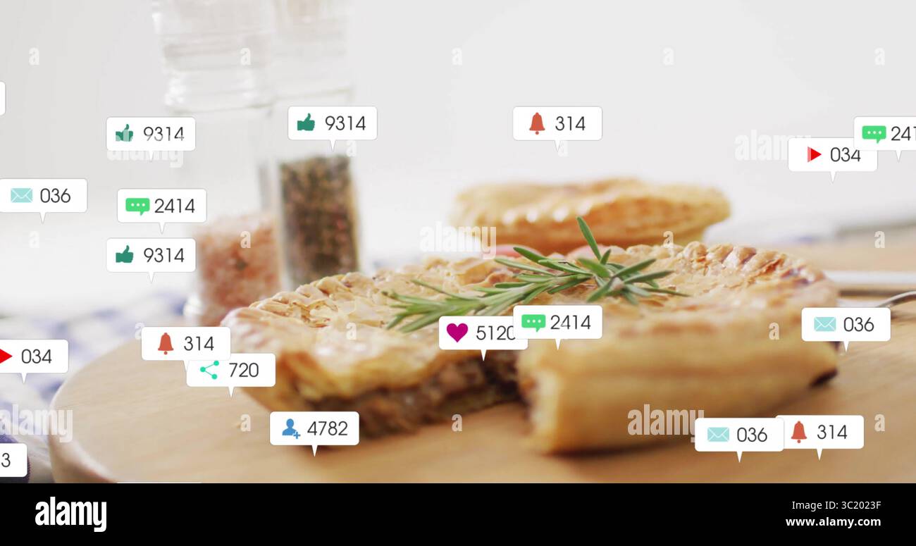 Tarte à la viande tranchée reposant sur une planche à découper sur le comptoir de cuisine, avec brin de romarin, icônes flottantes Banque D'Images