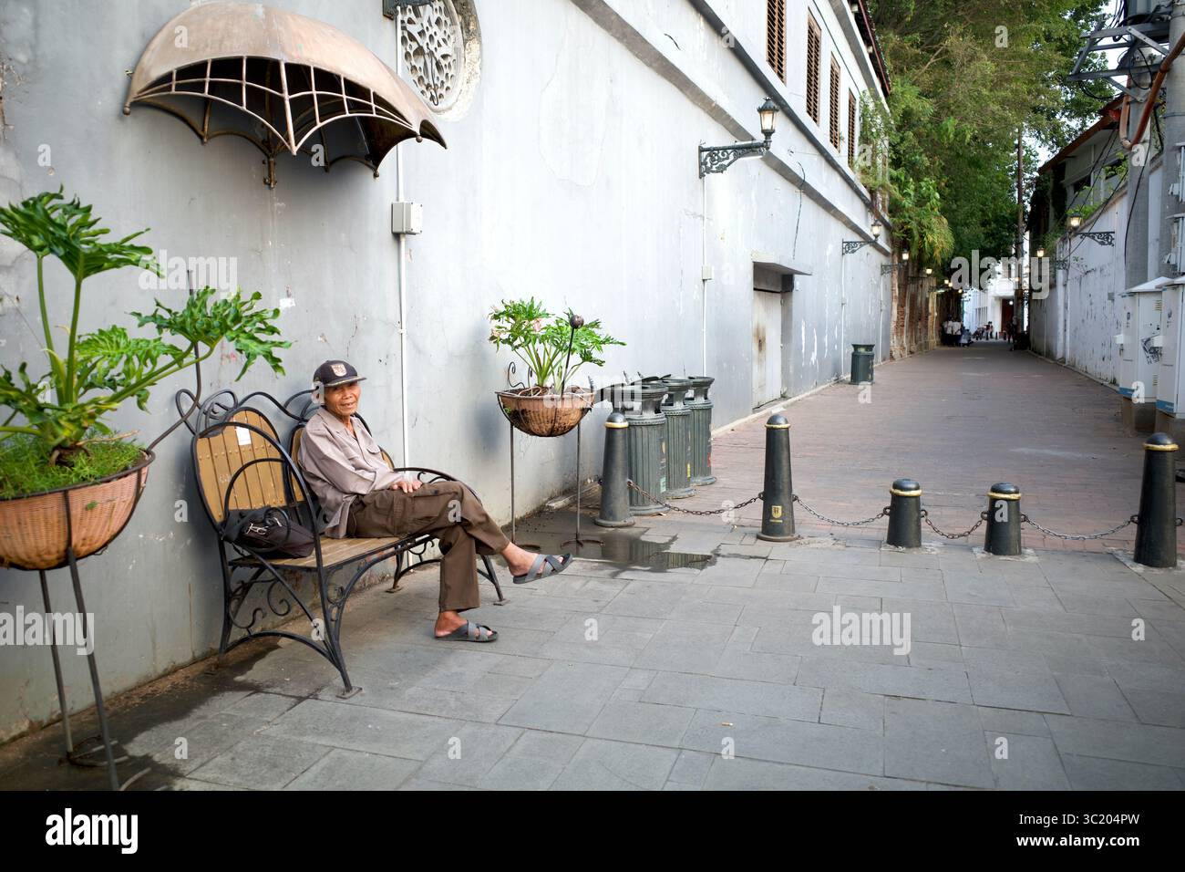 Semarang, Indonésie - 25 juillet 2024 : un vieil homme, un visiteur assis à Kota Lama Semarang, une zone de Semarang, Indonésie, un centre commercial dans les 19-2 Banque D'Images