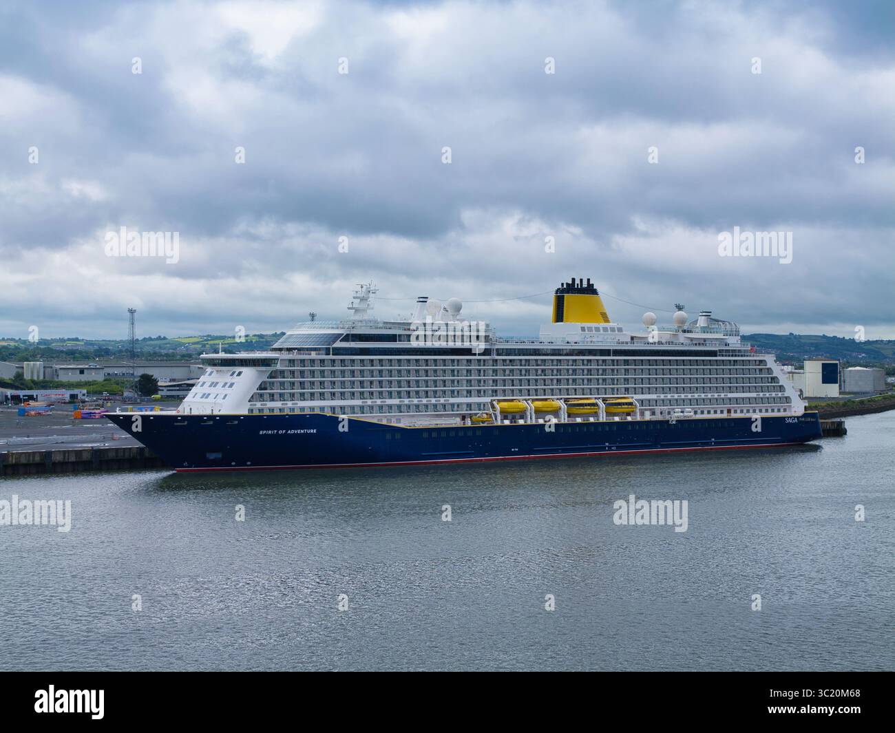 Belfast, Royaume-Uni - 15 juin 2025 : le bateau de croisière Spirit of Adventure est amarré dans le port de Belfast, sous un ciel sombre et couvert. Banque D'Images