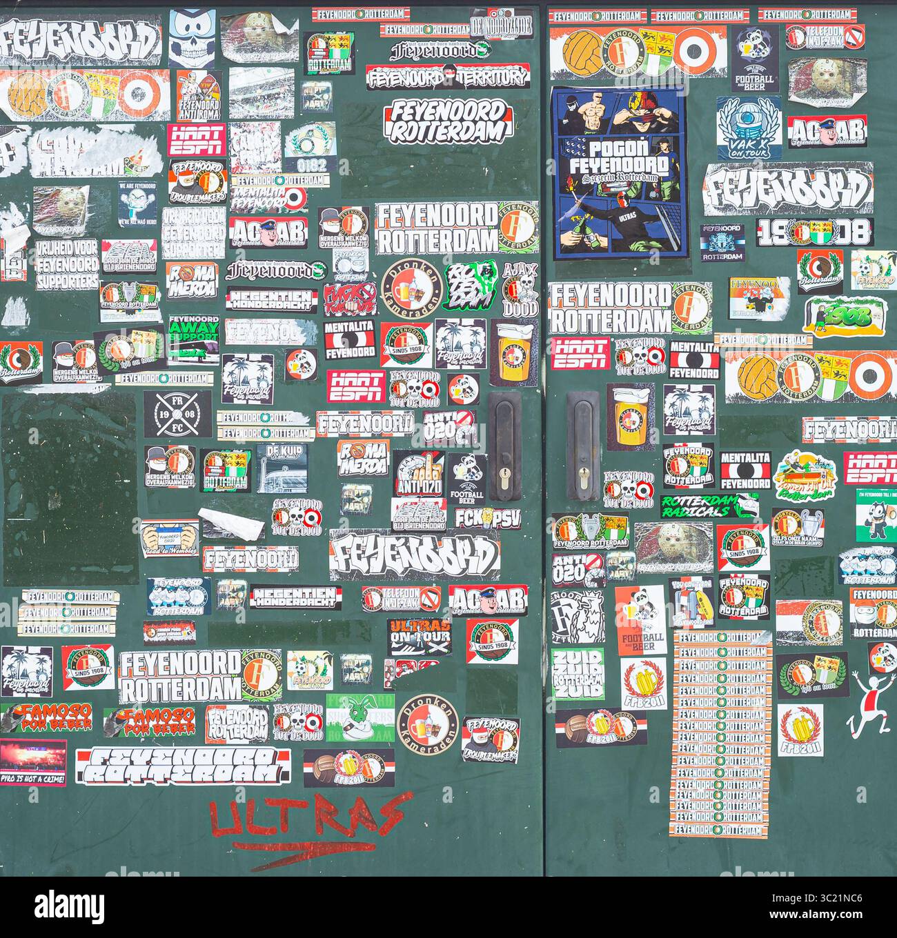 De nombreux autocollants de toutes formes et tailles du club de football néerlandais Feyenoord ont été collés sur un mur. Banque D'Images