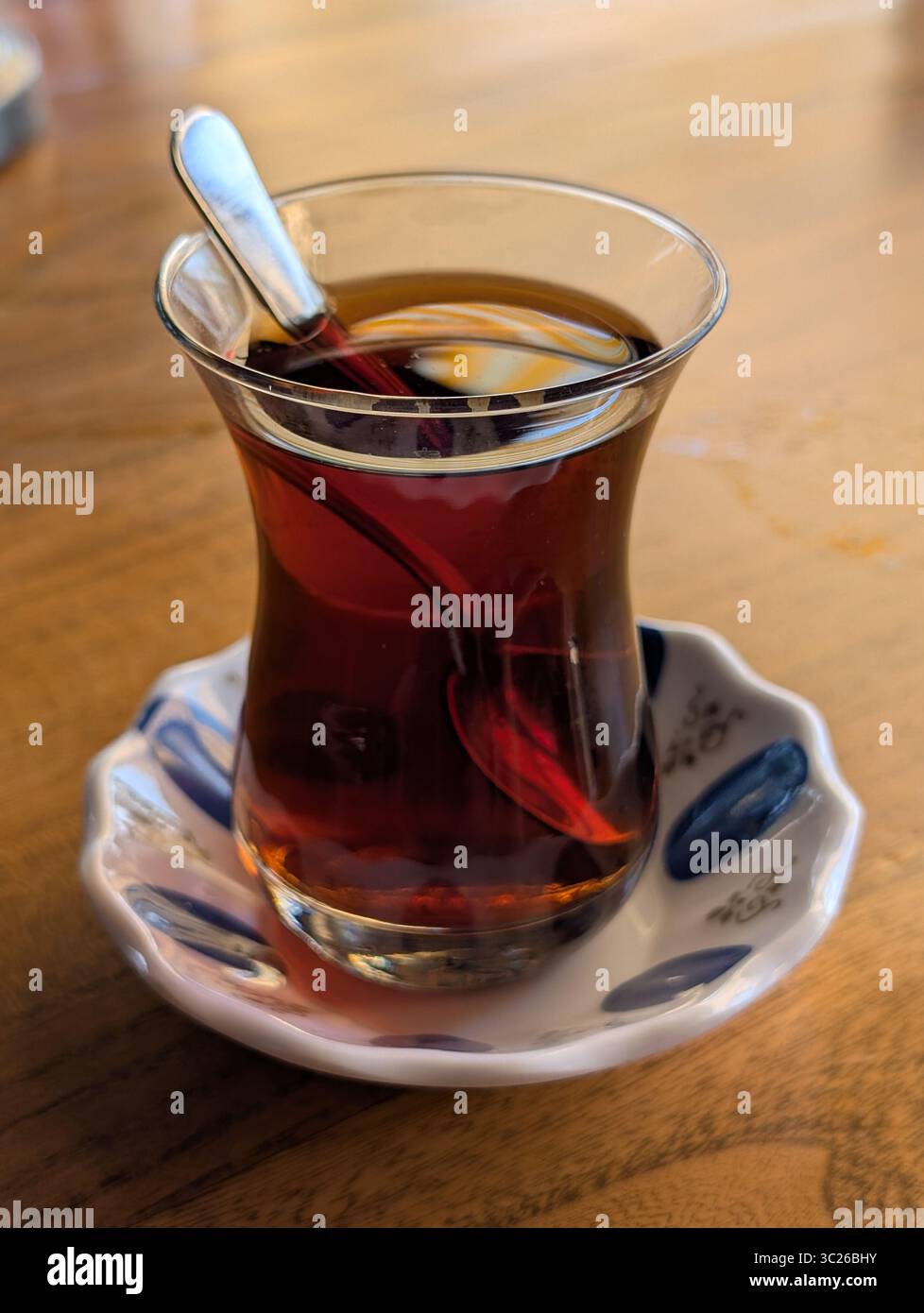 Une présentation classique du thé turc servi dans un verre en forme de tulipe, symbolisant la chaleur et l'hospitalité de la culture turque. Cette image capture t Banque D'Images