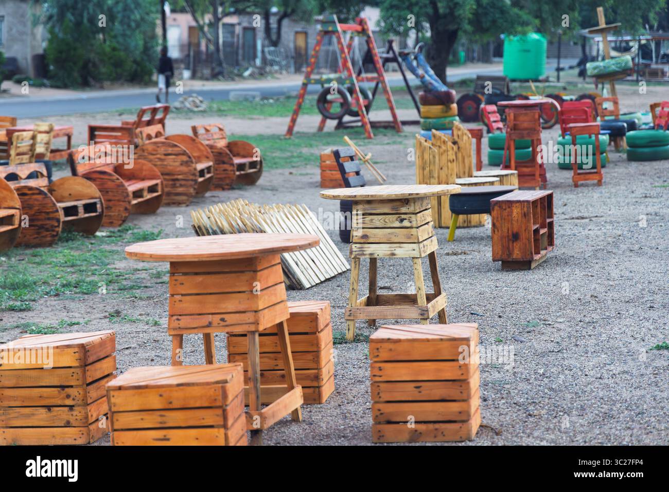 palette, clôture de bricolage, table, chaises, bancs et décorations, recyclage des palettes en bois , à l'extérieur dans le village africain township aire de jeux avec balançoire, Banque D'Images