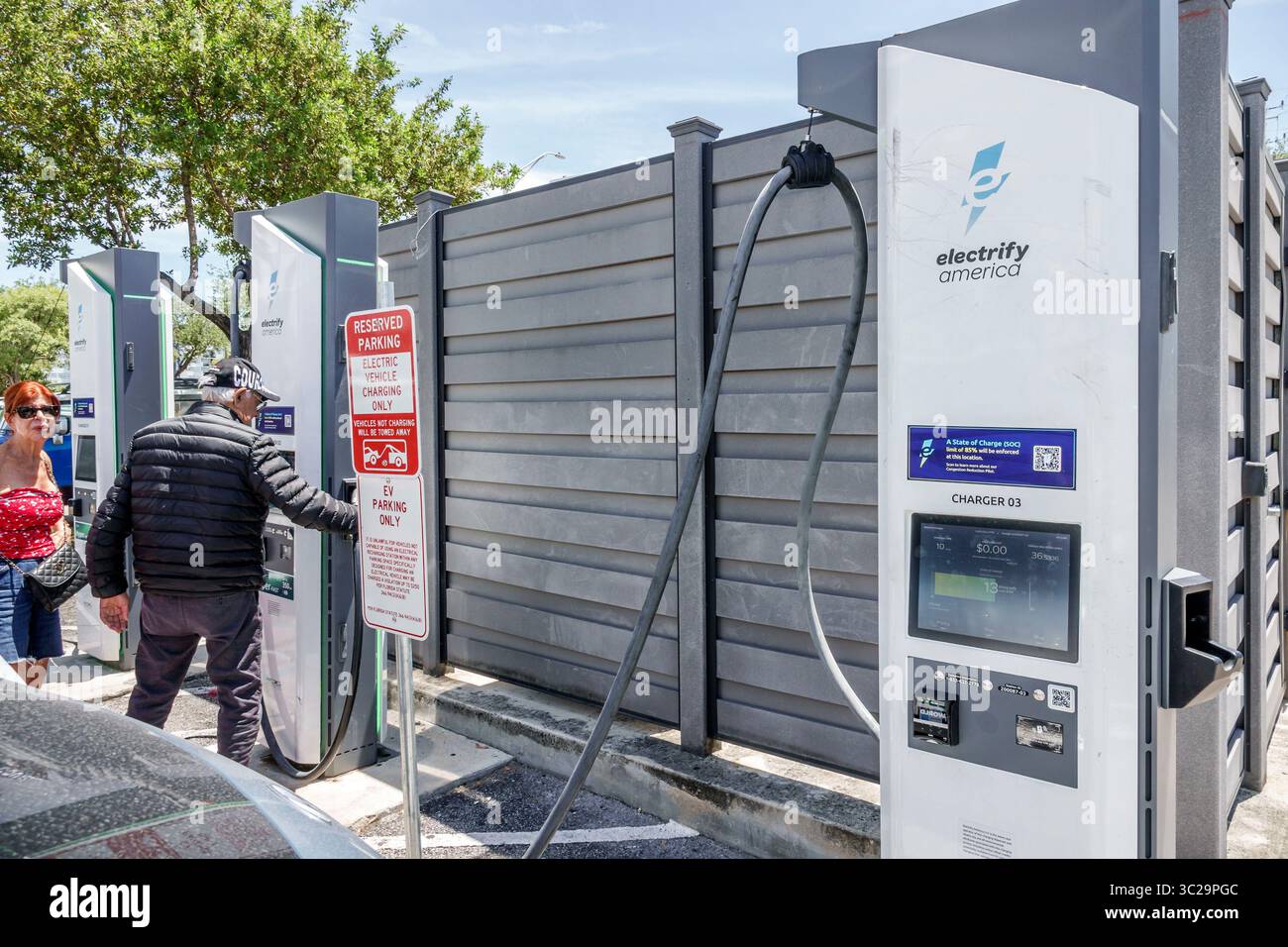 North Miami Beach Florida, Walmart discount grand magasin grande boîte, extérieur extérieur, mâle adulte mâle hispanique se branchant dans la voiture électrique à Electrify Banque D'Images