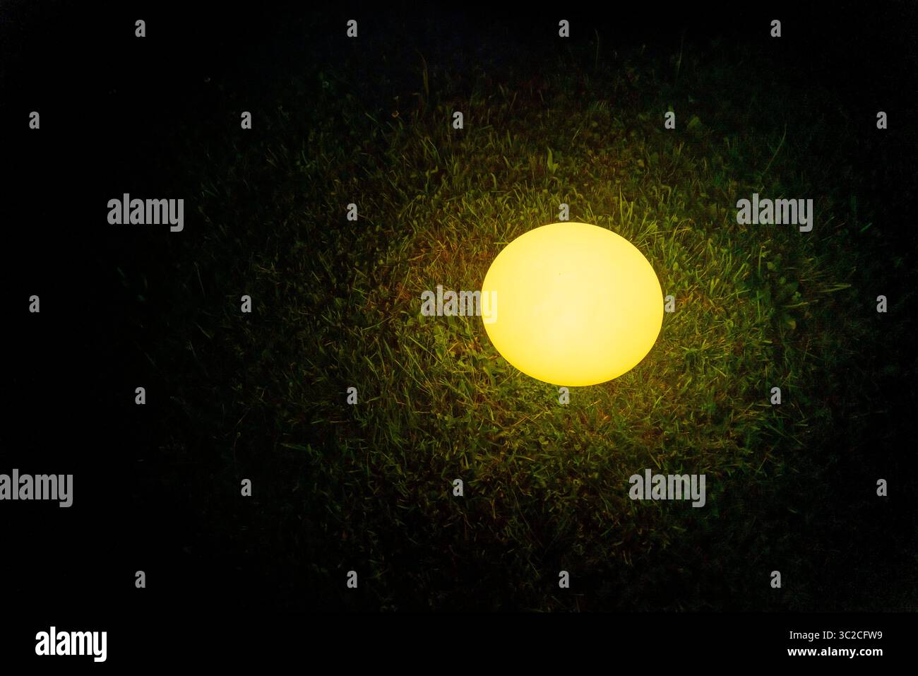 Scène nocturne montrant une lampe éclairée sur une pelouse Banque D'Images