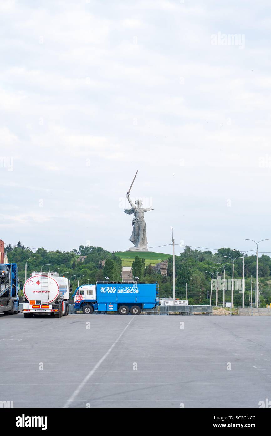 Kazan, Tatarstan - 15 juillet 2023 : L'emblématique patrie appelle une statue debout debout derrière des camions de rallye Silk Way stationnés et des véhicules de soutien Banque D'Images Kazan, Tatarstan - 15 juillet 2023 : L'emblématique patrie appelle une statue debout debout derrière des camions de rallye Silk Way stationnés et des véhicules de soutien Banque D'Images
