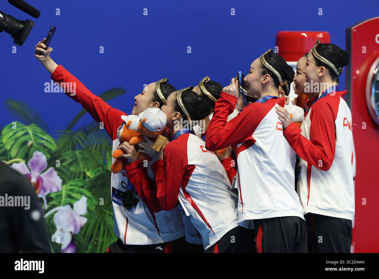 Les membres de l'équipe chinoise prennent des selfies pour commémorer le moment qui a suivi la cérémonie de remise des prix. Singapore City, Singapore.22th juillet 2025. L'équipe chinoise de natation artistique a remporté l'or avec un score de 307,8001 lors de la finale technique par équipe aux Championnats du monde de natation 2025 à Singapour, le 22 juillet 2025. L'équipe gagnante était composée de Chang Hao, Cheng Wentao, Dai Shiyi, Feng Yu, Li Xiuchen, lin Yanjun, Xiang Binxuan et Xu Huiyan. Crédit : Fu Tian/China News Service/Alamy Live News Banque D'Images
