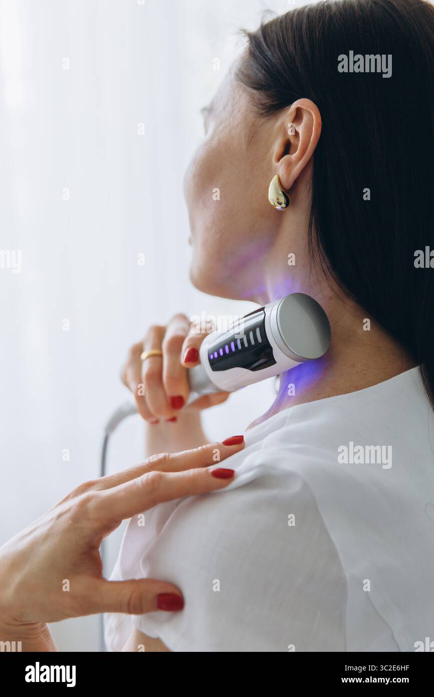 Gros plan de la thérapie endosphérique sur la région du cou de la femme à l'aide d'un appareil de massage esthétique. Traitement anti-âge et relaxation en clinique de beauté. Haute qualité Banque D'Images Gros plan de la thérapie endosphérique sur la région du cou de la femme à l'aide d'un appareil de massage esthétique. Traitement anti-âge et relaxation en clinique de beauté. Haute qualité Banque D'Images