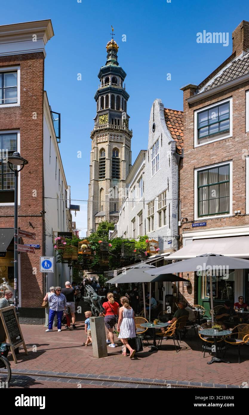 Middelburg, Zeeland, Niederlande - Fussgaengerzone Korte Delft an der Ecke Reigerstraat. Die kleine immer wieder geschmueckte Gasse, hier Vogelbauer, in der Altstadt ist eine Sehenswuerdigkeit der Stadt. In der Umgebung gibt es viele CafÃ s und Geschaefte. Hinten der Tall John Abbey Tower, ein restaurierter Kirchturm aus dem 14. Jahrhundert mit 207 steinernen Stufen zu einer Aussichtsgalerie. Middelburg Zeeland Niederlande *** Middelburg, Zeeland, pays-Bas zone piétonne Korte Delft au coin de Reigerstraat la petite ruelle décorée à plusieurs reprises, ici Vogelbauer, dans la vieille ville est une Banque D'Images