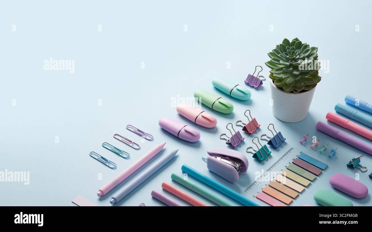 Bannière de papeterie avec des fournitures de bureau de couleur pastel soigneusement disposées sur fond bleu clair. Place pour votre texte. Banque D'Images