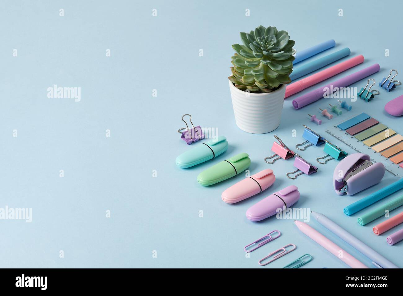 Bannière de papeterie avec des fournitures de bureau de couleur pastel soigneusement disposées sur fond bleu clair. Place pour votre texte. Banque D'Images