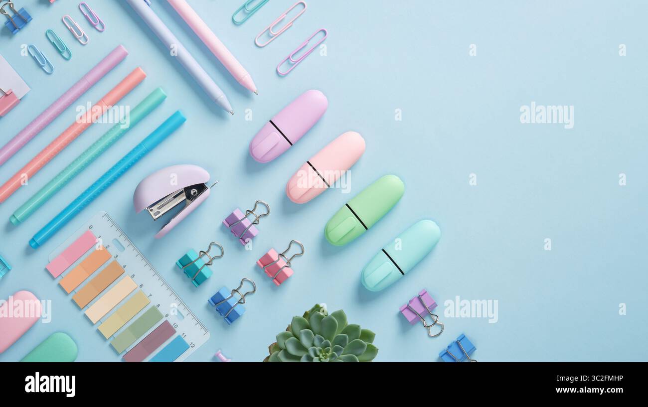 Bannière de papeterie avec des fournitures de bureau de couleur pastel soigneusement disposées sur fond bleu clair. Place pour votre texte. Banque D'Images