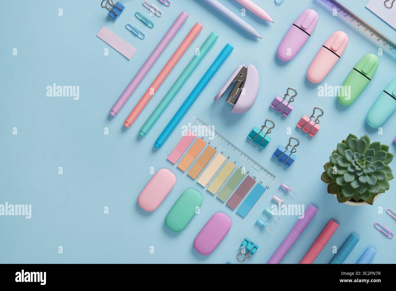 Bannière de papeterie avec des fournitures de bureau de couleur pastel soigneusement disposées sur fond bleu clair. Place pour votre texte. Banque D'Images