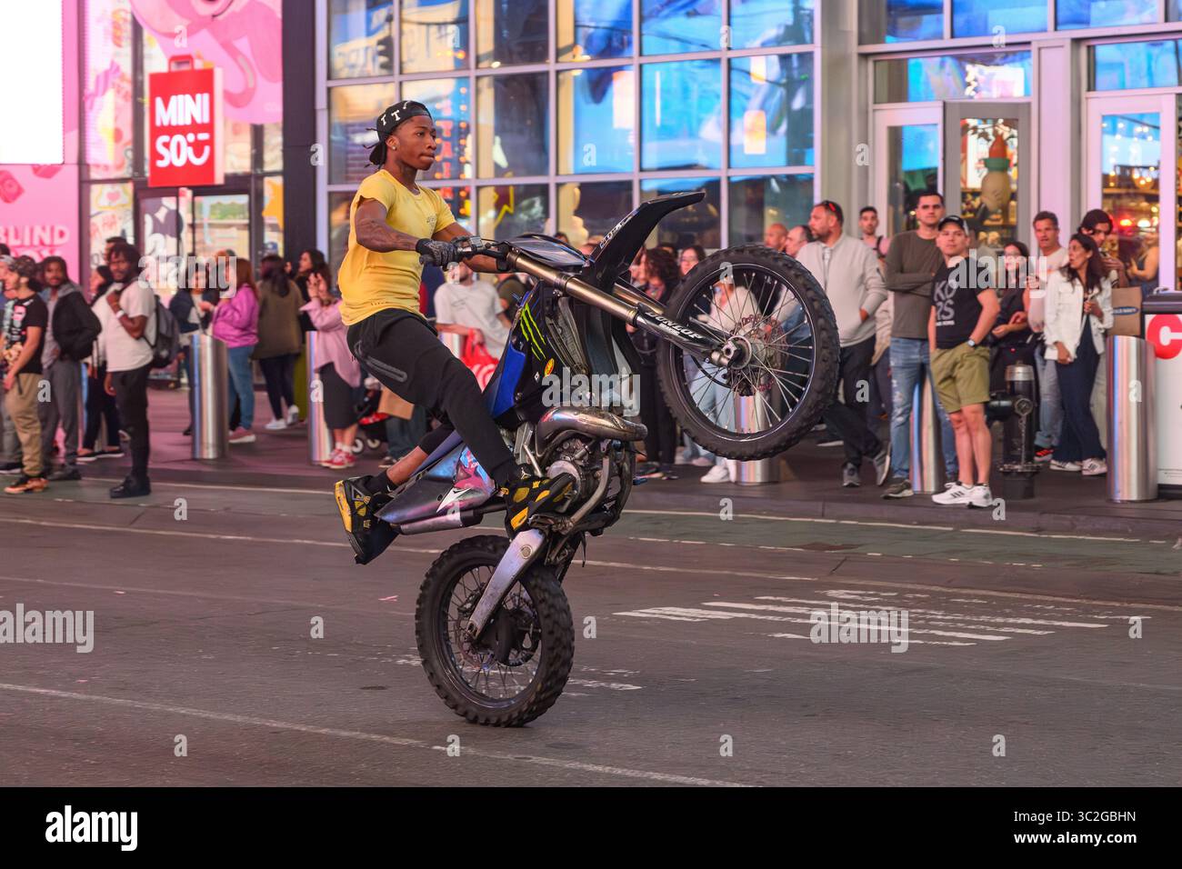 Un cavalier hors route en vélo tout terrain tirant Une Wheelie sur la 7e avenue à Times Square New York City Banque D'Images