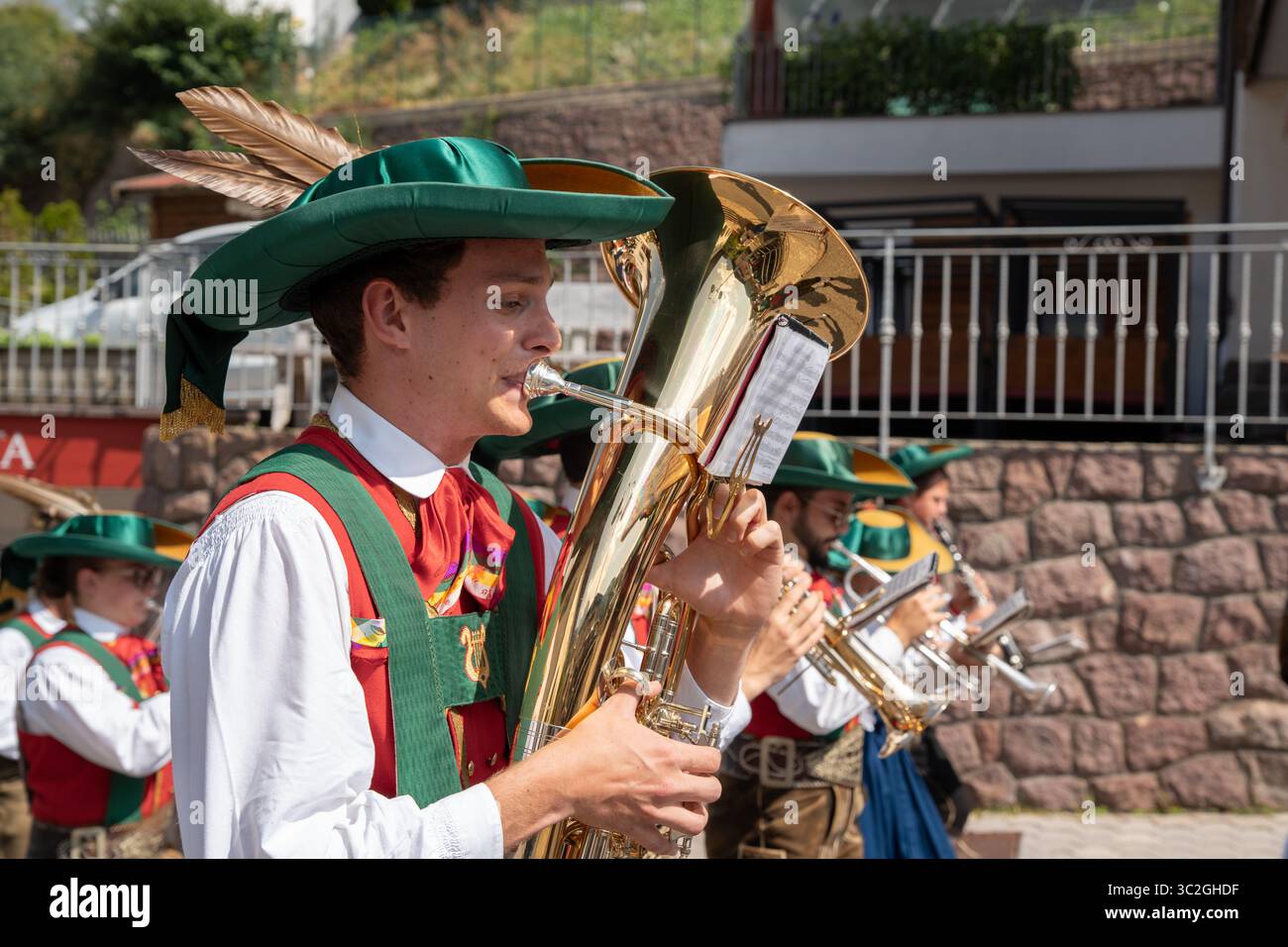 Homme jouant un cor de baryton dans une fanfare folklorique portant un tracht et lederhosen du sud du tyrol lors d'un festival à Val Gardena Banque D'Images
