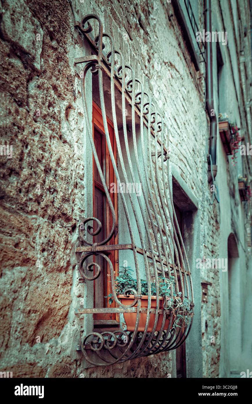 Charmante fenêtre méditerranéenne avec ferronnerie ornée en Toscane Banque D'Images