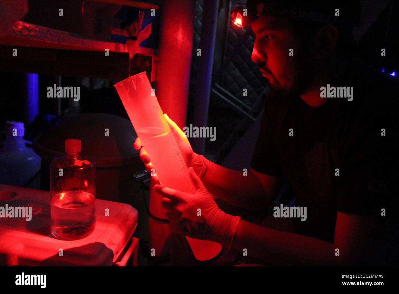 11 juillet 2019 - il, États-Unis - Justin Podowski, un étudiant diplômé de l'Université de Chicago qui étudie la microbiologie, porte une lampe frontale rouge le 28 juin 2019, alors qu'il recueille des spécimens de micro-organismes du lac supérieur en filtrant l'eau recueillie à des centaines de pieds sous la surface. De nombreuses espèces qui résident à ces profondeurs peuvent être sensibles à la lumière. Le bateau Blue Heron a accueilli des chercheurs de l'Université de Chicago qui étudiaient les micro-organismes dans les grands Lacs. (Crédit image : © TNS via ZUMA Wire) Banque D'Images